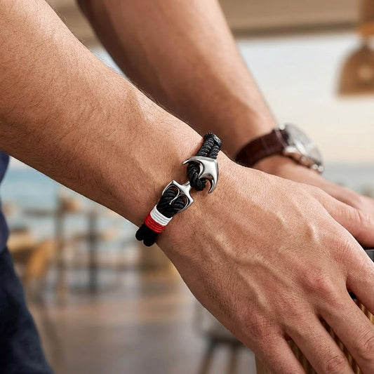 Bracelet noir Avec Une Ancre argenté sur le poignet d'un homme