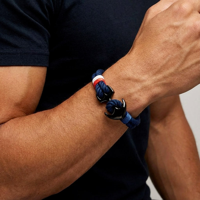 Bracelet bleu blanc rouoge avec ancre noir sur le poignet d'un homme