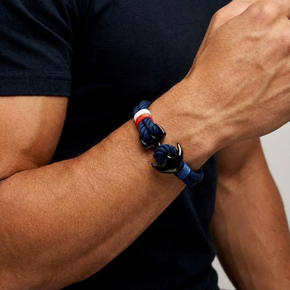 Bracelet bleu blanc rouoge avec ancre noir sur le poignet d'un homme