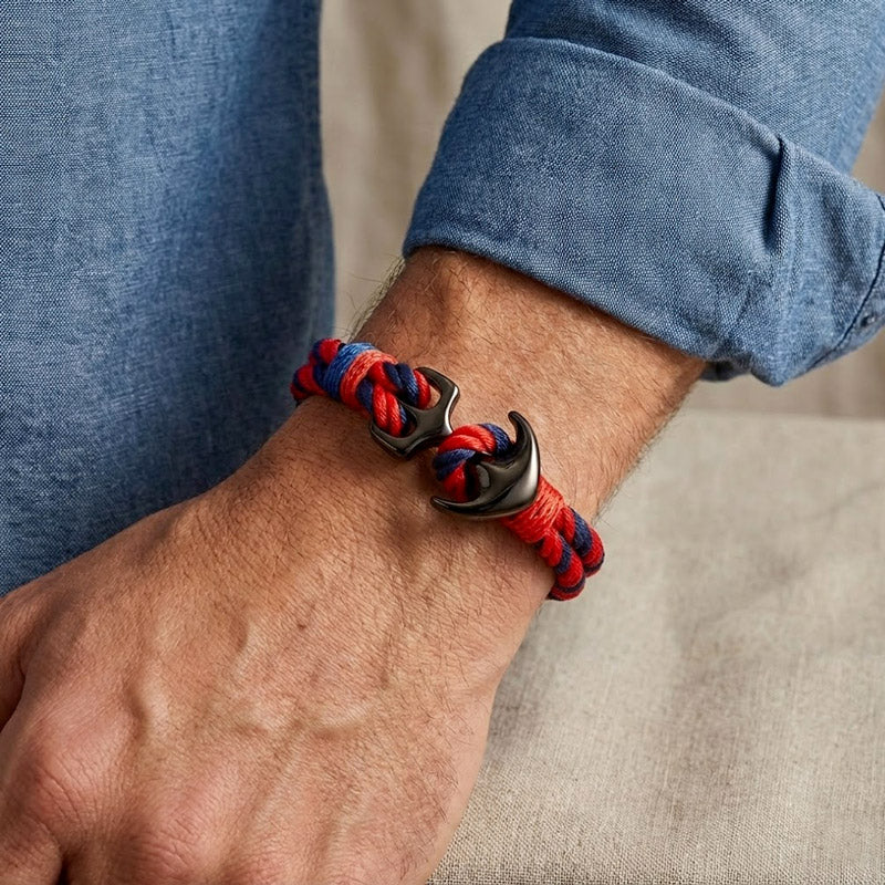 Bracelet rouge et bleu ancre noir porté sur le poignet d'un homme