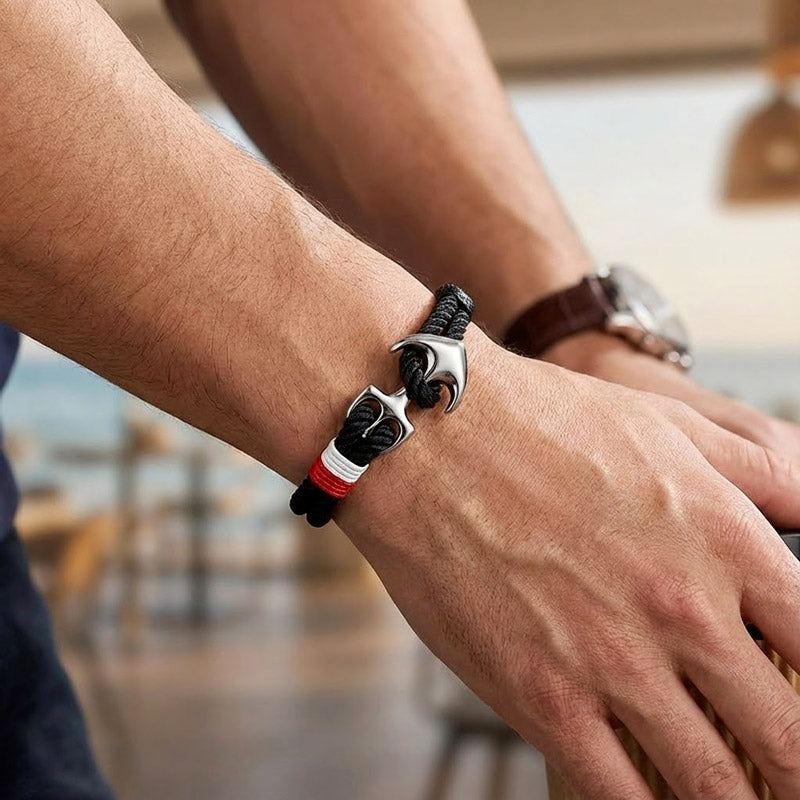 Bracelet noir Avec Une Ancre argenté sur le poignet d'un homme